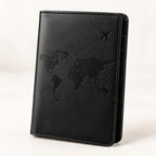 Black passport cover with embossed world-map motif on a white background